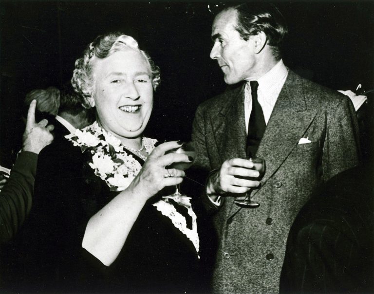 Agatha Christie and Collins enjoying a drink at a party.